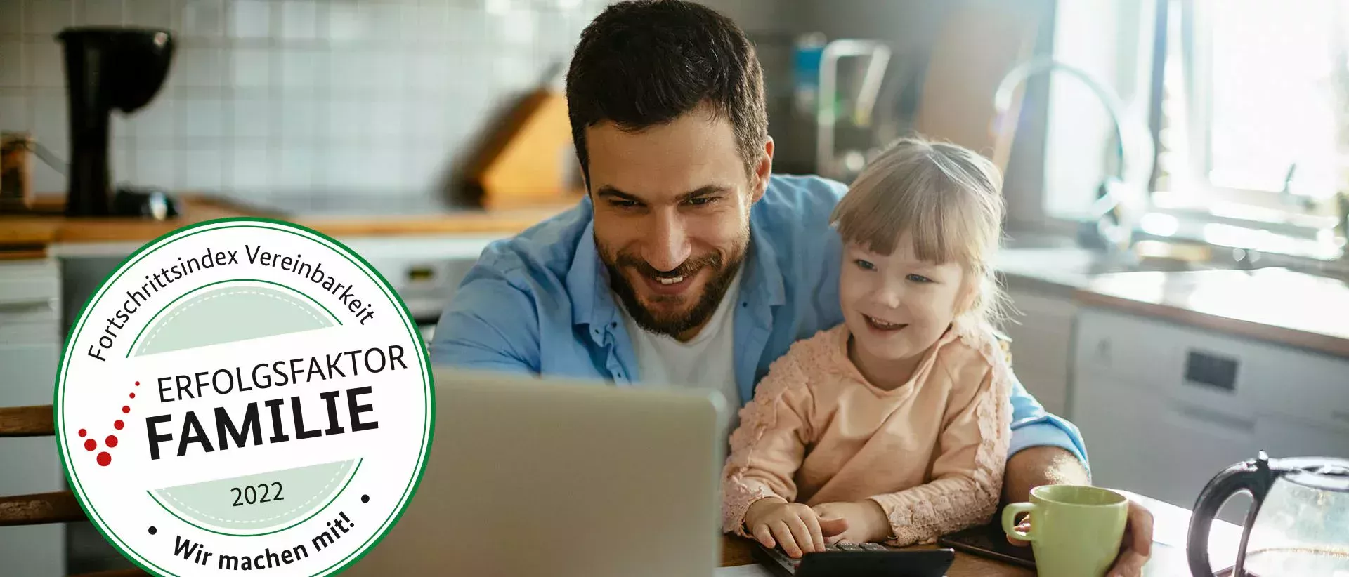 父亲带着年幼的女儿坐在厨房的餐桌旁,他们开心地看着面前的笔记本电脑。